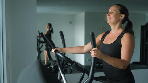 Woman working out on elliptical machine at gym