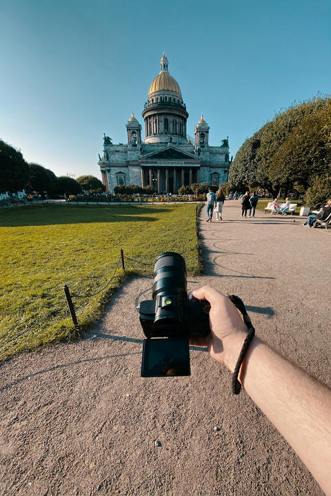 Man takes a picture of a large historic church