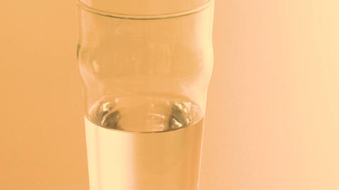 Minimal table scene with half filled glass water in quiet indoor environment