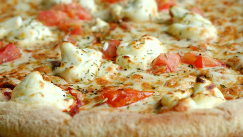 Delicious baked pizza with cheese and tomato rotating