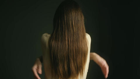 Woman with long hair hugging herself from behind