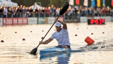 Kayaker crossing finish buoy during flatwater sprint race with powerful paddle
