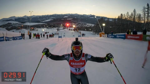 Alpine skier celebrating victory at downhill finish line on snowy mountain race