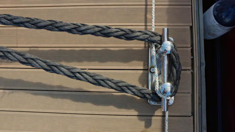 the pier at the yacht club, the thick rope of the moored boat, the fender