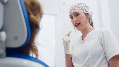Dentist explaining dental care to patient in clinic