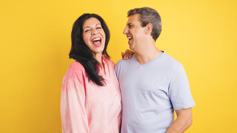 Happy couple laughing together celebrating positive emotions