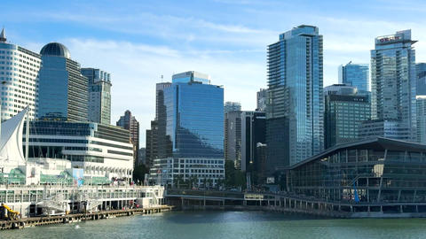 City skyline view of Vancouver with buildings and waterfront under clear sky in afternoon light