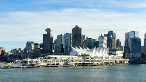 City skyline view of Vancouver with buildings and waterfront under clear sky in afternoon light