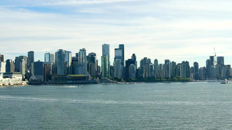 City skyline view of Vancouver with buildings and waterfront under clear sky in afternoon light