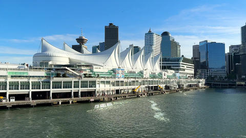 City skyline view of Vancouver with buildings and waterfront under clear sky in afternoon light