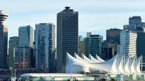 City skyline view of Vancouver with buildings and waterfront under clear sky in afternoon light