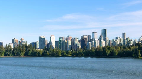 City skyline view of Vancouver with buildings and waterfront under clear sky in afternoon light