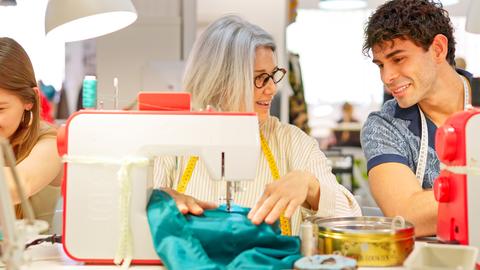 People learning sewing skills in textile workshop