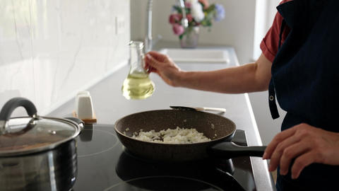 Woman Pouring Oil Into Pan With Onions