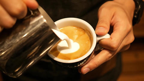Barista creating intricate latte art in a continuous top-down shot