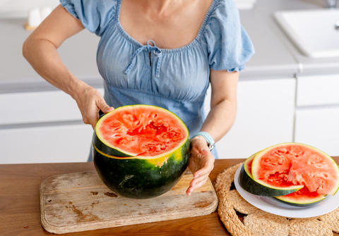 Woman Cutting Ripe Watermelon