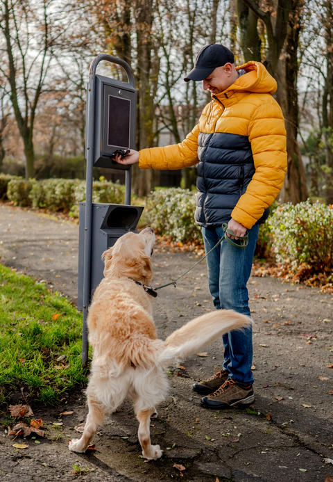 Man Taking Dog Waste Bags From Special Stand
