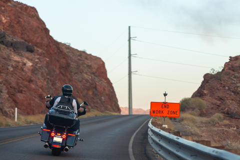 Equipped motorcyclists traveling on winding mountain route