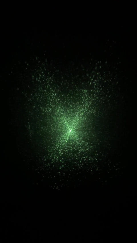 Green laser light creates dynamic visual patterns, transitioning from a scattered effect