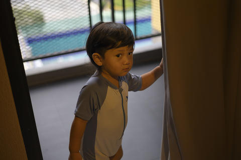 Little Boy Driving A Plastic Ride On Car In Playroom