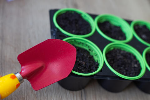 Gardening trowel filling pots with soil for planting