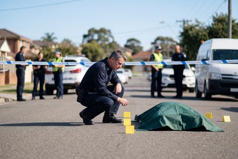 Police officer investigating crime scene on a suburban street with colleagues