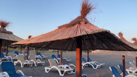 Sand beach Adriatic Sea with sunbeds and umbrellas at sunset, Ulcinj, Montenegro