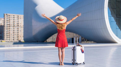 A young Caucasian female traveler admiring Heydar Aliyev Center. Baku, Azerbaijan