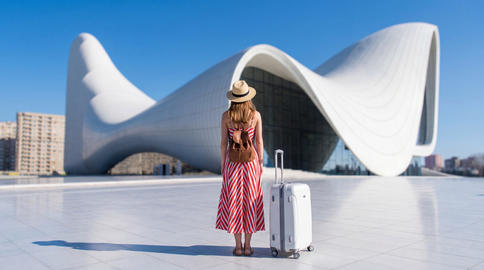 A young Caucasian female traveler admiring Heydar Aliyev Center. Baku, Azerbaijan