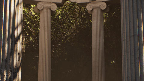 Ancient greek ionic order columns in a lush green forest