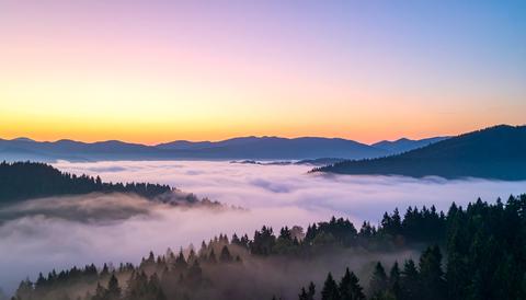 Misty Mountain Silhouettes at Dusk with Purple Pastel Sky