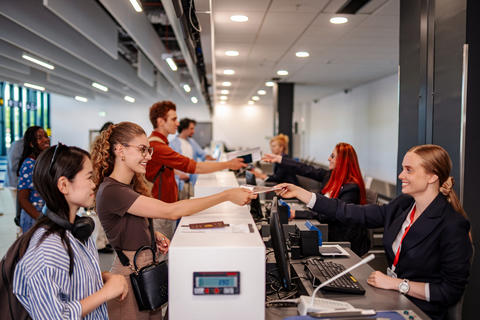 Passengers checking in at airport with airline staff