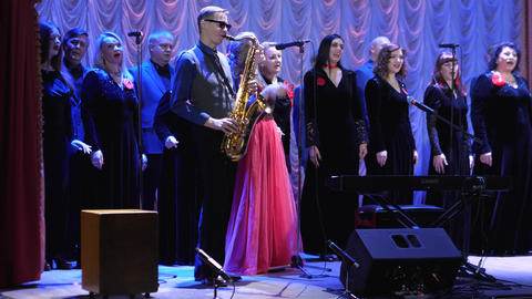 Gomel, Belarus - 11.25.2022: A male saxophonist in sunglasses at center stage