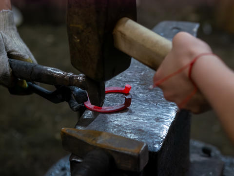 Blacksmith Forging Glowing Hot Horseshoe on Anvil