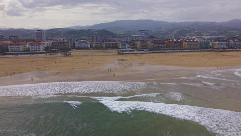 Aerial view of surfers and sandy beach coastline