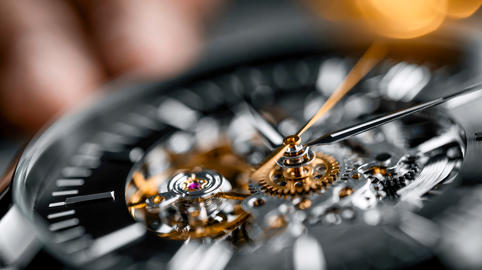 Macro view of an intricate mechanical watch movement with polished gears and hands, representing pre