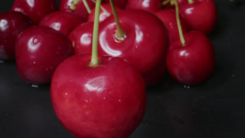 Bright red cherries piled on a dark background