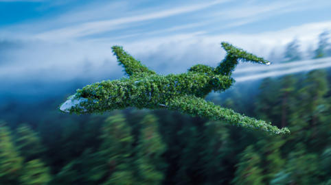 Green jet plane flying over a dense forest for sustainable aviation