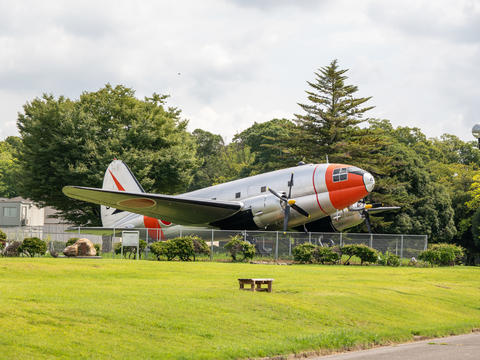 Vintage Propeller Aircraft Displayed Outdoors in a Park with Green Lawn