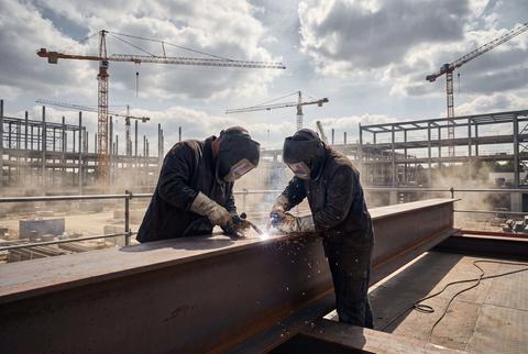 Industrial Welders Working on Steel Beams at Active Construction Site
