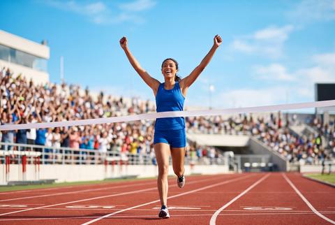 Female Runner Crossing Finish Line During Athletic Sprint Race Competition
