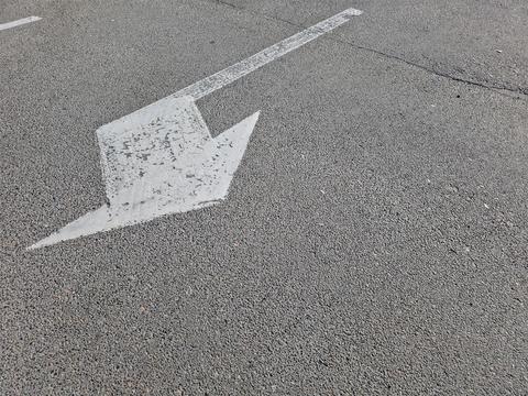 Clear Directional Arrow on Asphalt Guiding Vehicles in a Spacious Parking Lot