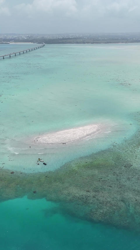 Vertical drone footage of Yuni no Hama beach, Miyakojima Okinawa, orbiting under cloudy summer skies