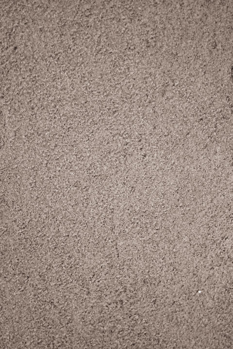 Vertical shot of a concrete wall with a smooth texture and gray color with a granular surface
