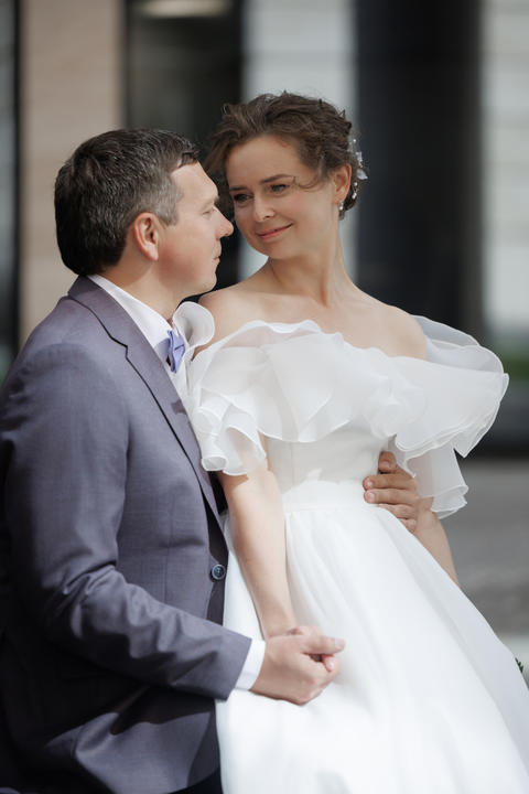 Bride and groom embrace closely on an urban street