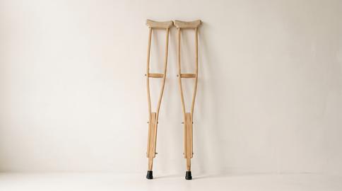 Pair of wooden crutches leaning against wall for injury recovery