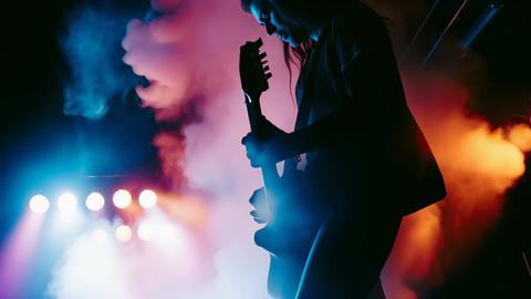 Silhouette of a Guitarist Performing on Stage with Smoke and Stage Lights