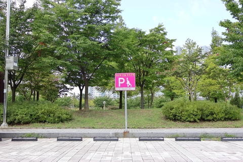 Parking Sign and Green Space in a Korean Urban Park