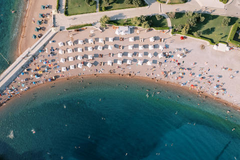 Aerial view of Budva beach umbrellas swimmers and shoreline