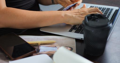 Hands typing on laptop while holding credit card for secure online shopping at